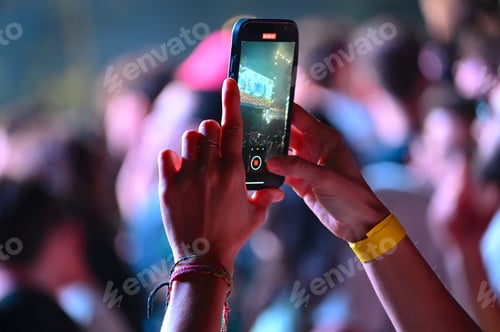 Preview: Closeup of female hands taking a video with smartphone on blur background