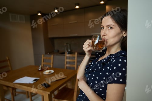 Preview: Beautiful woman in a cute dress is drinking tea