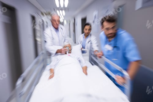 Preview: Doctor and nurse pushing emergency stretcher bed in corridor