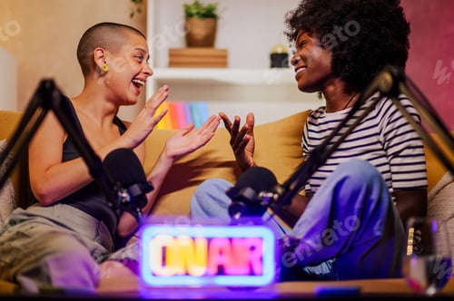 Preview: Two diverse women recording episode of internet podcast in a modern studio