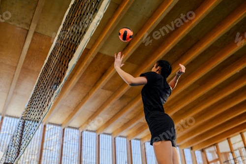 Preview: Low angle view of interracial volleyball player hitting a ball over net.