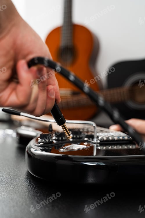 Preview: Jack plugged into black electric guitar activating sound output