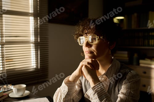 Preview: Middle Aged Caucasian Woman Contemplating at Desk in Sunlit Office