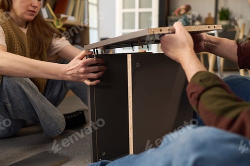 Preview: Young Woman and Young Man Assembling Furniture Together
