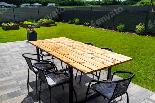 Preview: A modern table made of raw wood covered with yacht varnish, standing on the garden terrace.