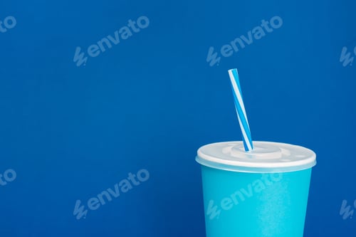 Preview: paper cup with soda on blue background with copy space
