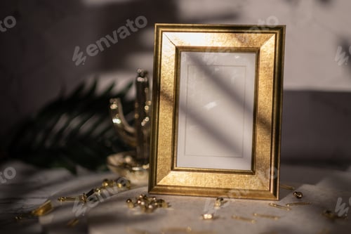 Preview: blank picture frame on stone stand with gold stationery at whtie marble table background