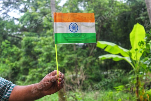 Preview: Closeup of the flag of India on a small stick being held by a person