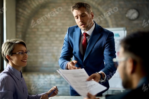 Preview: Businessman going through paperwork with his colleagues on a meeting in the office.