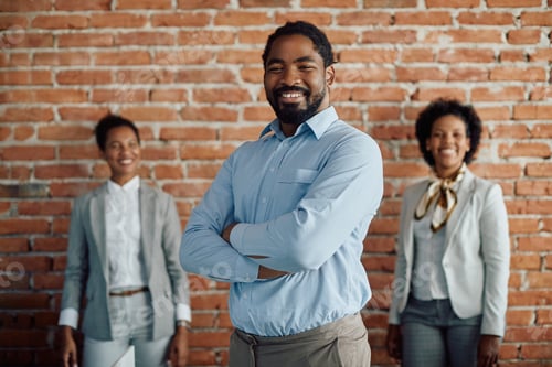 Preview: Portrait oh happy African American business leader with female coworkers in the background.