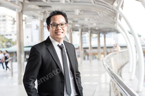 Preview: Happy businessman standing on walkway of building