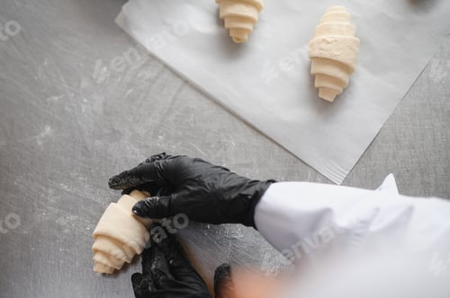 Preview: Baker preparing croissants in bakery: placing dough on metal table