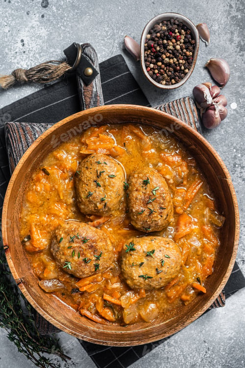 Preview: Cutlets or Fish balls with tuna in tomato sauce. Gray background. Top view