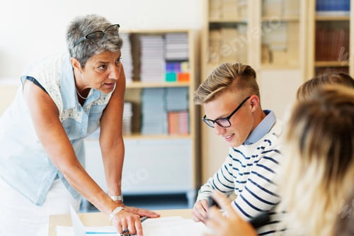 Preview: Mature teacher explaining students in classroom