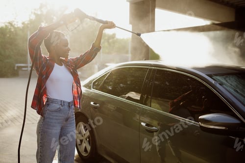 Preview: Woman holds high pressure water gun, car wash
