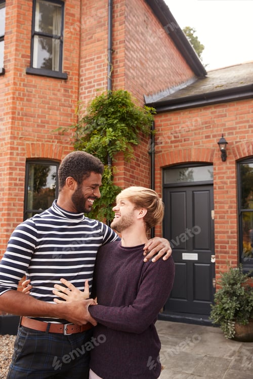 Preview: Excited Gay Male Couple Standing Outside New Home On Moving Day Together