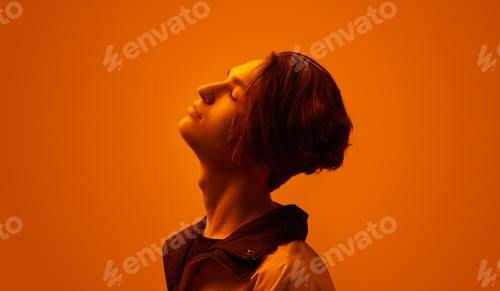 Preview: Dreamy young guy in studio with neon illumination