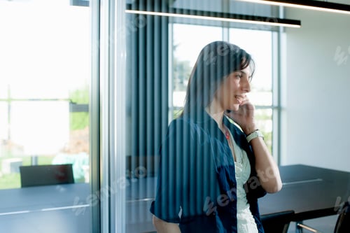 Preview: Businesswoman on smartphone behind glass wall