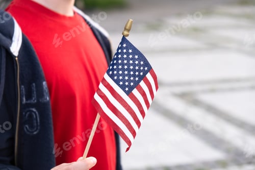 Preview: American flag in boy's hand outdoors. 4th july USA independence day concept
