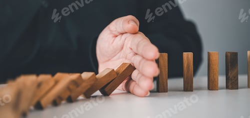 Preview: close-up hand The hand of a businessman who is stopping or preventing a falling block.