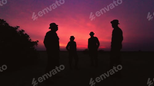 Preview: Silhouette of four men wearing hats standing against a beautiful sunset sky