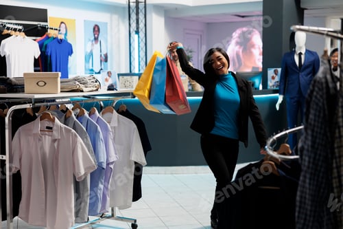 Preview: Woman holding paper bags while shopping