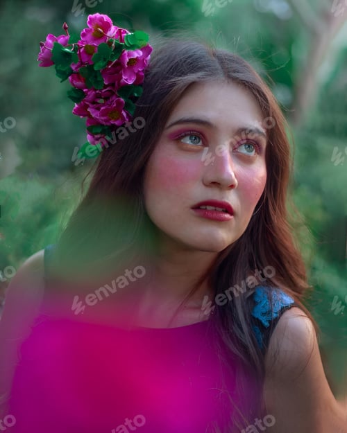Preview: Young woman in an elegant outfit surrounded by lush greenery and flowers