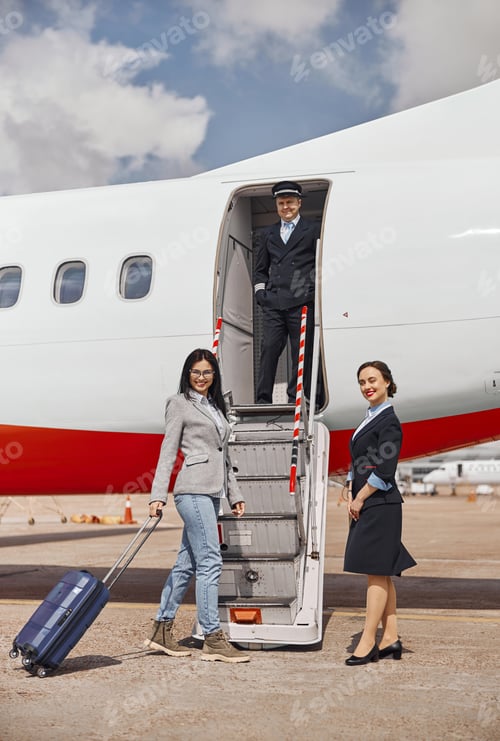 Preview: Happy female passenger is boarding on a plane