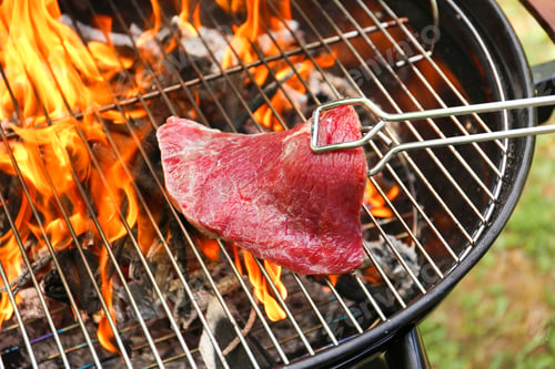 Preview: Tasty meat on barbecue grill with fire flames outdoors, closeup