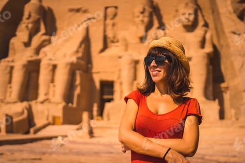 Preview: A Young Tourist In A Red Dress Smiling At The Abu Simbel Temple In Southern Egypt In Nubia Next To