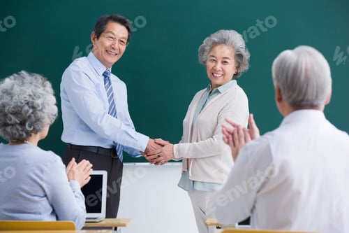 Preview: Senior student having a handshake with teacher in classroom