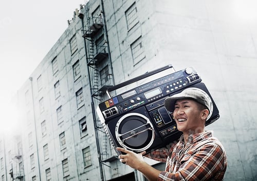 Preview: A young person with a boombox on the street of a city.