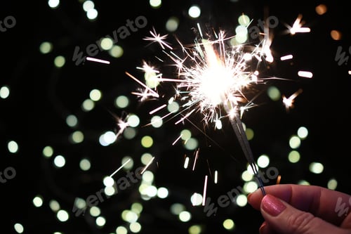 Preview: Female holding sparklers shining sparkling with white lights in background, celebration celebrate