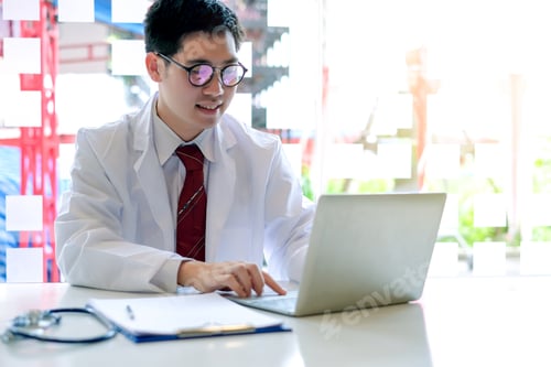 Preview: Young male doctor asian working with laptop in the office