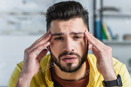 Preview: Close up of bearded businessman man touching head at workplace
