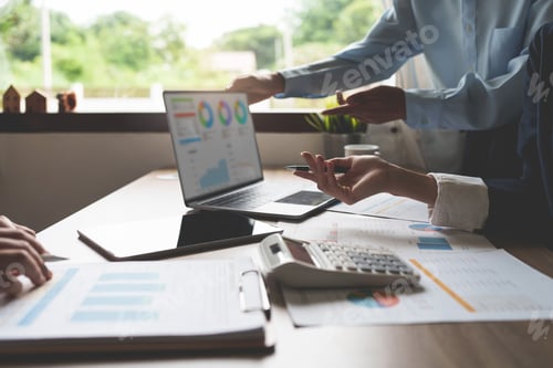 Preview: Business Professionals Reviewing Charts and Graphs on Laptop