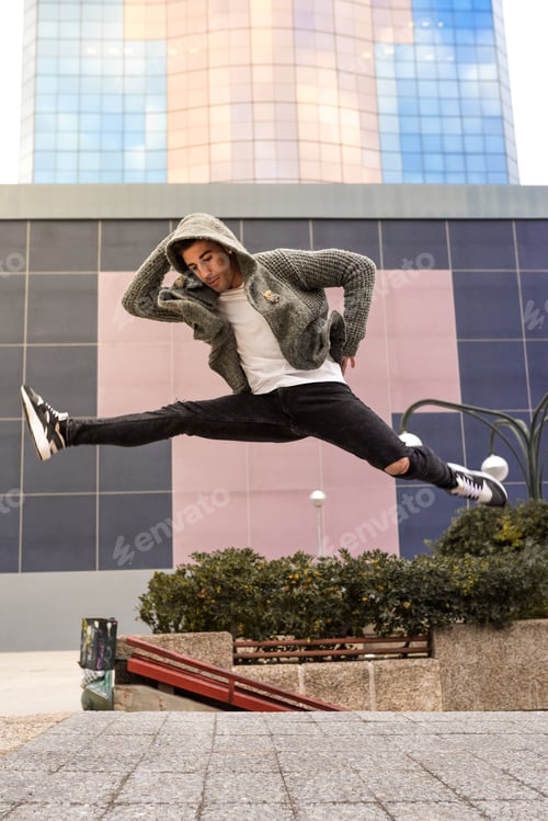 Preview: Happy young man dancing and jumping in the street