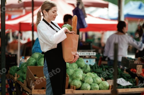 Preview: Woman seller at the market with products in a paper bag