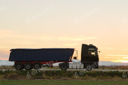 Preview: Semi-truck with tipping cargo trailer transporting sand from quarry driving on highway