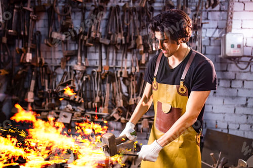 Preview: Authentic handsome indian man in leathern apron hammer industry small business