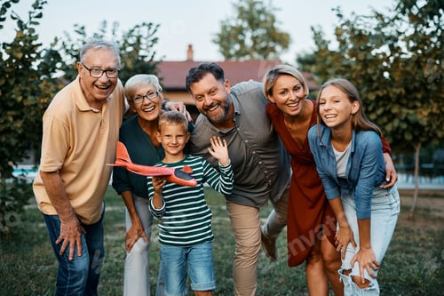 Preview: Portrait of cheerful extended family in the backyard looking at camera.