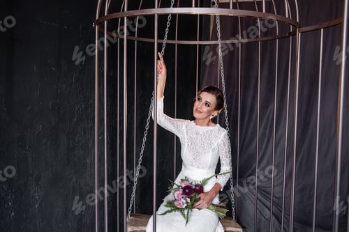 Preview: Elegant Woman Posing in Birdcage with Floral Bouquet