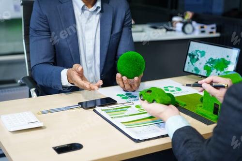 Preview: A meeting at an office desk focuses on teamwork with a house model and discussions on electric cars