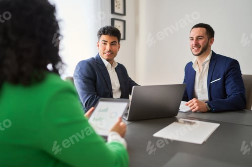 Preview: Three people are sitting at a table, one of them holding a tablet