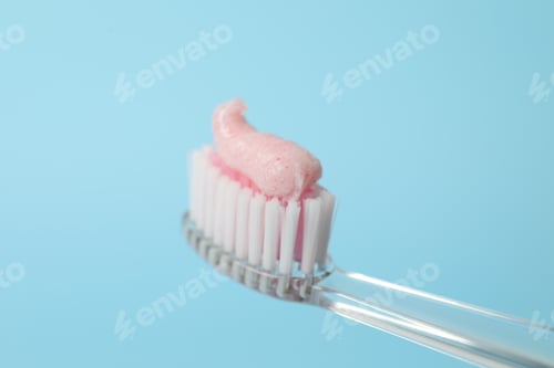 Preview: Brush with toothpaste against turquoise background, closeup