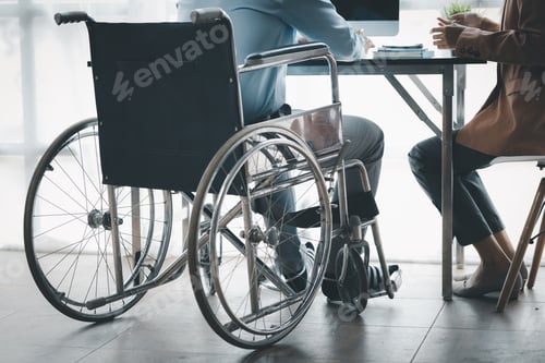 Preview: Man sits in wheelchair and brainstorms with colleagues.