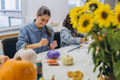 Preview: Smiling Woman and Child Painting Pumpkins at Table