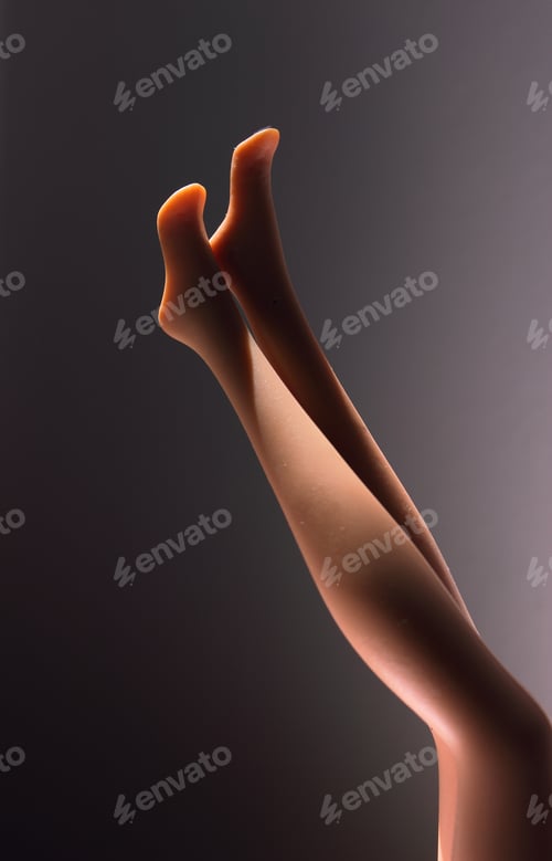 Preview: Vertical closeup shot of plastic mannequin's legs with a dark background