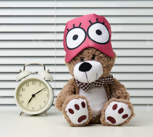 Preview: Brown teddy bear sits with a bandage for sleeping on a white table