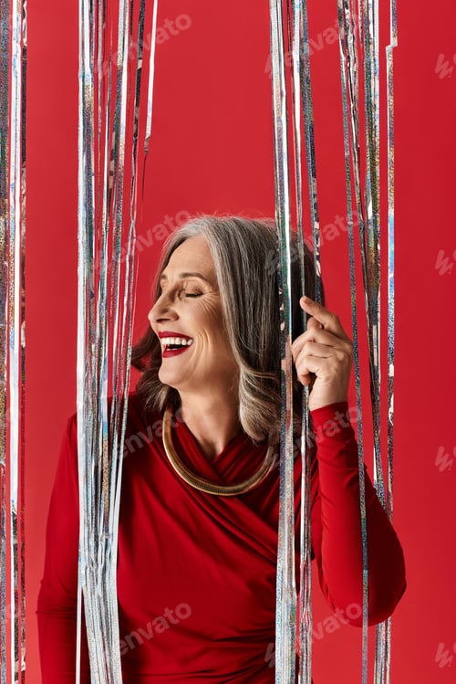 Preview: Joyful celebration of Christmas and New Year by a beautiful mature woman with grey hair